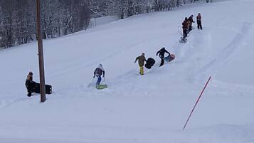 A snowy slope with people skiing and snowboarding.