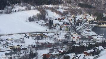 Lumipeitteinen kaupunki, jossa on rakennuksia, silta ja vesistö.