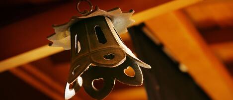 A hanging bell with heart-shaped cutouts.
