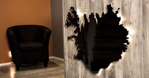 A room with a wooden wall featuring a large, irregularly shaped cutout. - Lava Apartments (Akureyri)
