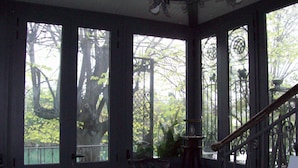 A room with large windows, a staircase, and a desk with a computer. - Villa Fiorita (Monfalcone)