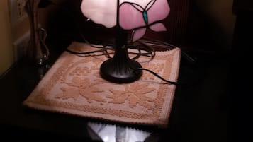Una lámpara de mesa con pantalla floral sobre un mantel texturizado.