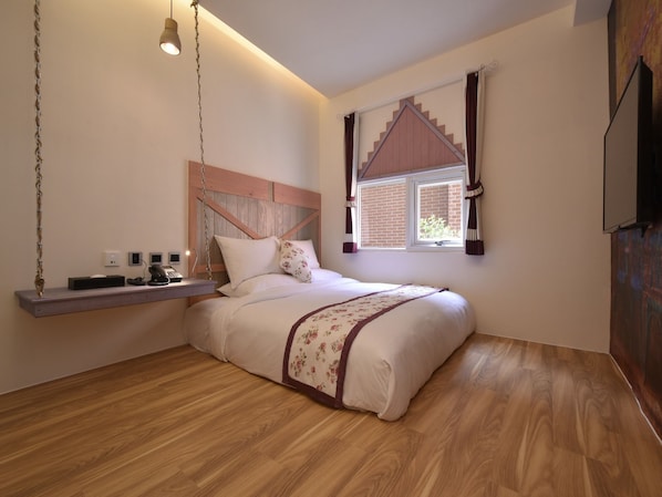 Quarto com cama, mesa de cabeceira, luminária pendente, janela com cortinas e televisão na parede.