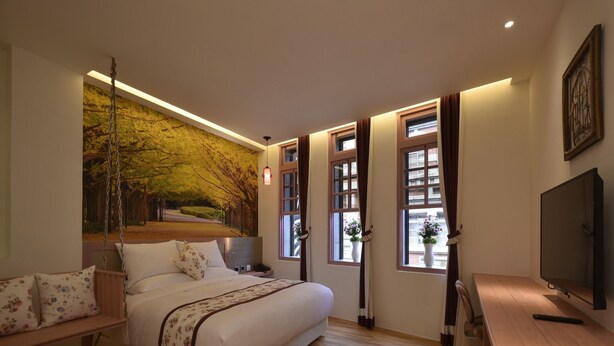 A modern bedroom with a large bed, a desk, and a TV. - DG Hotel (Taipei)
