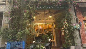 A building with a cafe and hotel signage, featuring stone facade and large windows. - DG Hotel (Taipei)