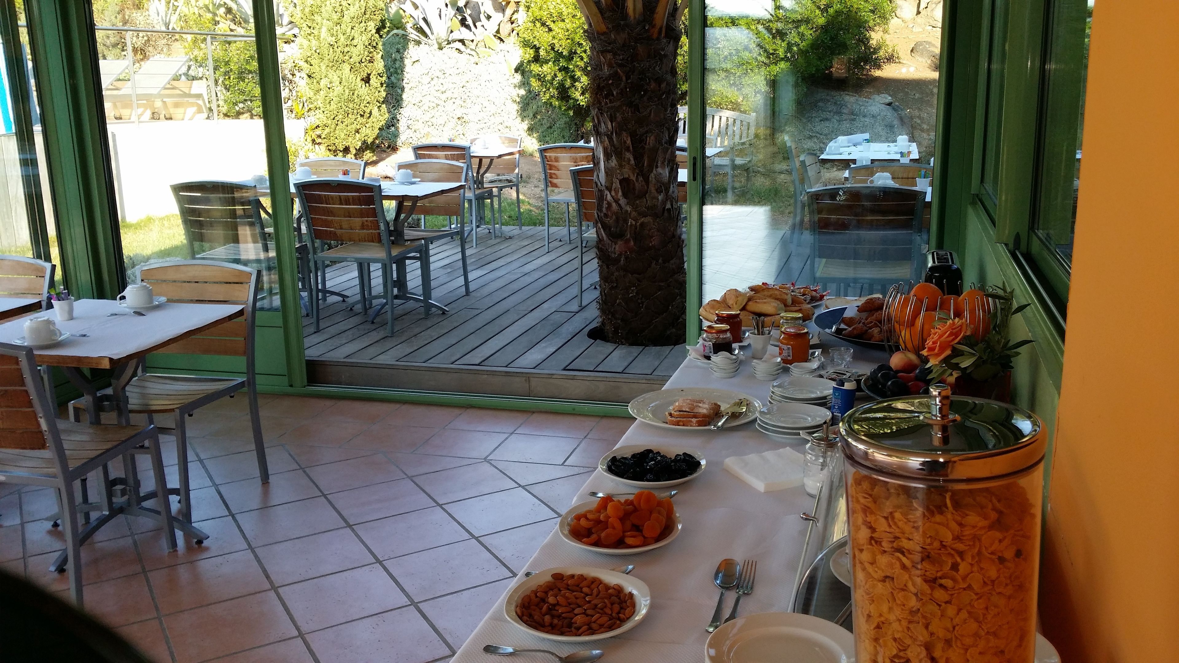 Un bufé de desayuno con diversos alimentos y un gran árbol al fondo.
