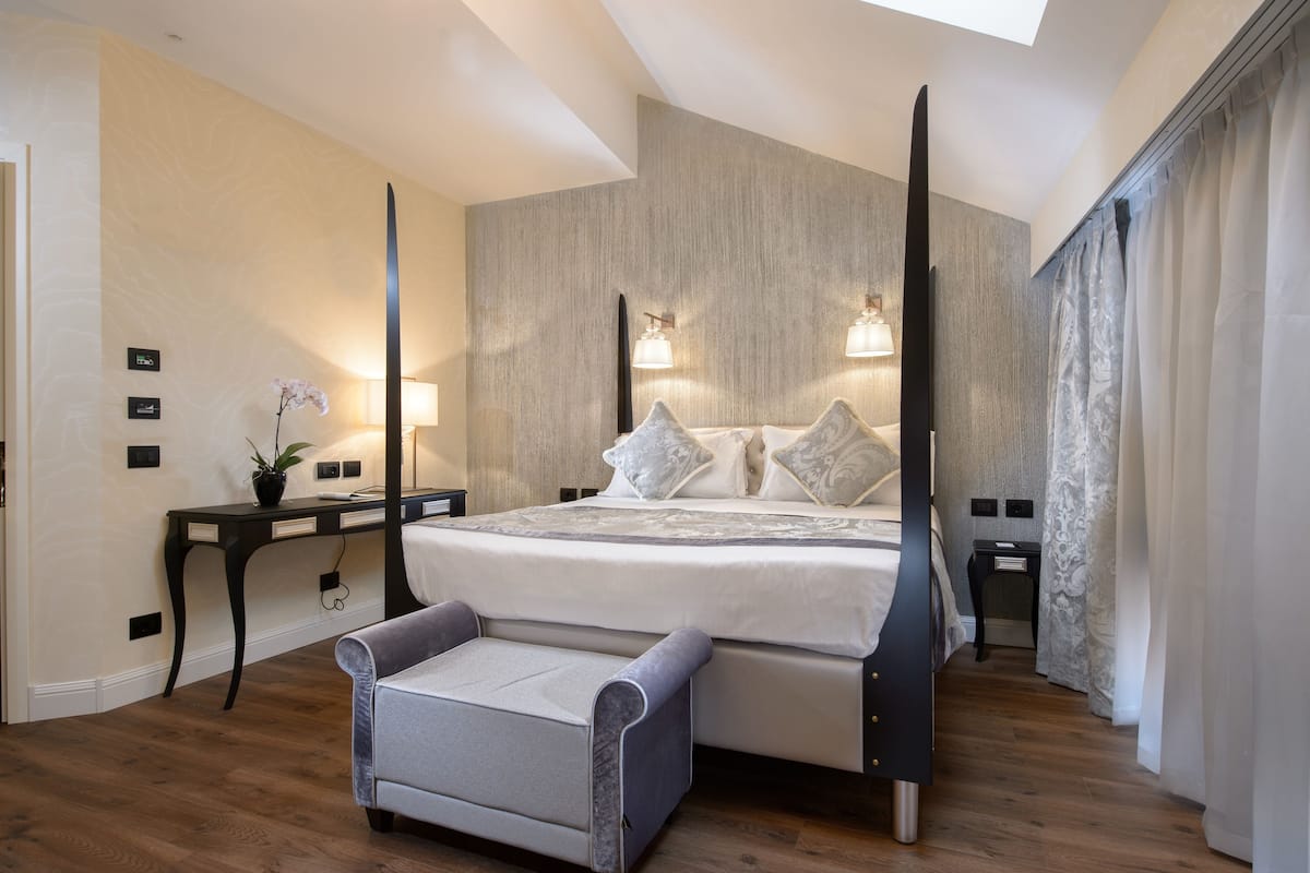 Ein modernes Schlafzimmer mit einem großen Bett, Nachttischen, einem Schreibtisch und einem Stuhl.
