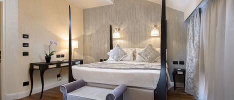 A modern bedroom with a large bed, bedside tables, a desk, and a chair.