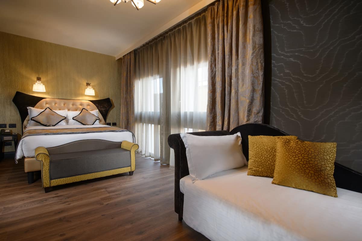Ein Hotelzimmer mit einem großen Bett, einer Sitzecke und einem Schreibtisch.