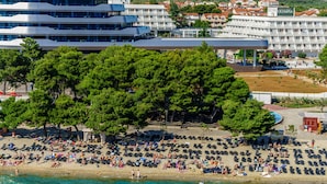 Uma praia com vários espreguiçadeiras e pessoas aproveitando o mar.