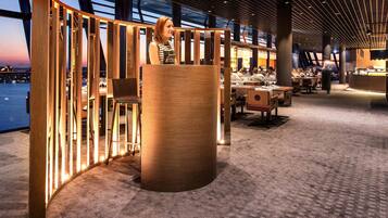 A spacious indoor area with a high ceiling, featuring a grid-like ceiling design and a large wooden column.