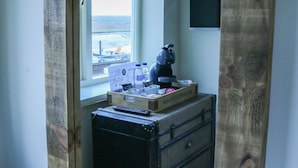 A room with a window, a suitcase, and a coffee maker on a table. - The Quay B&B (Wells-next-the-Sea)