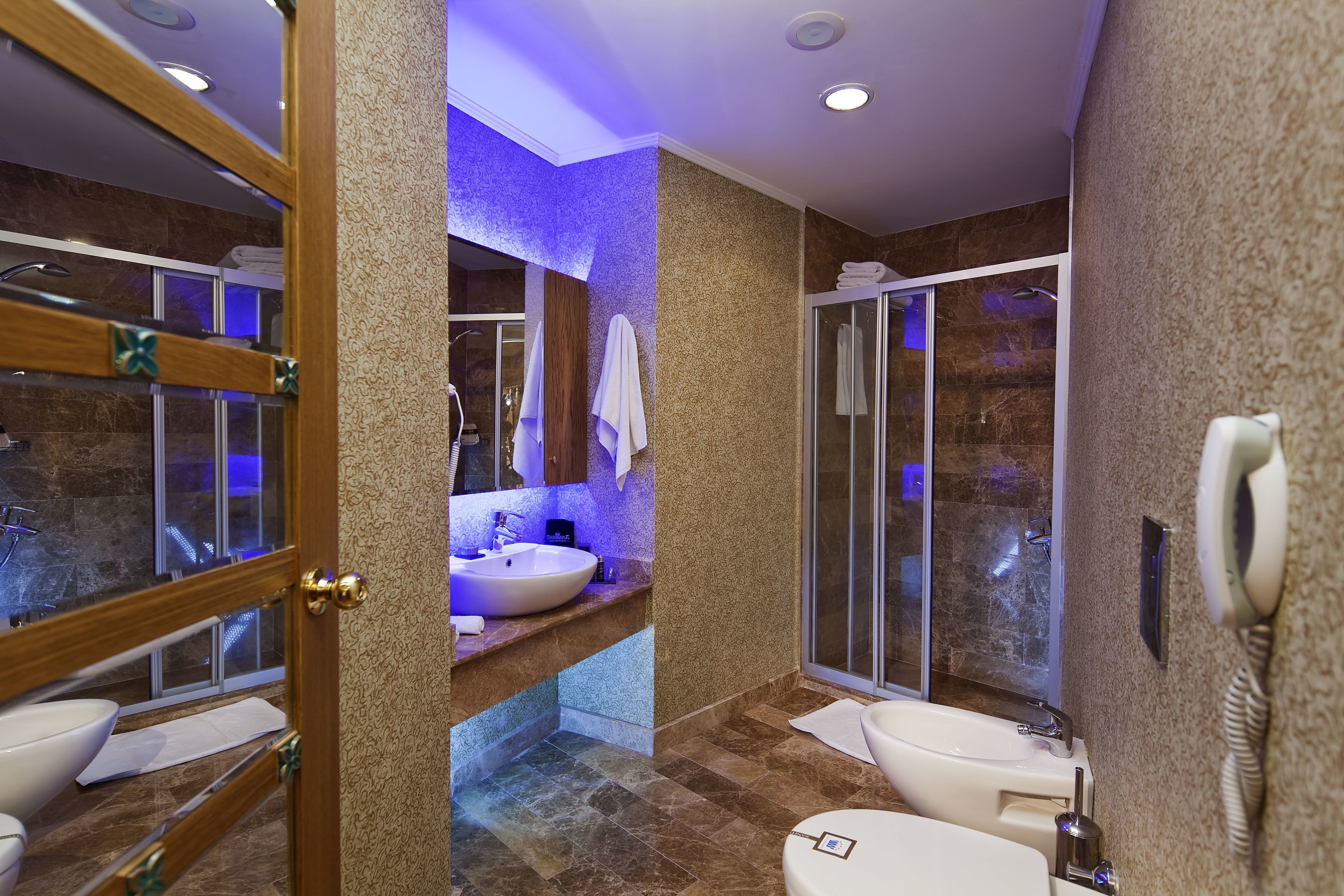 A modern bathroom with a vanity, sink, and separate shower area.