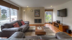 Una sala de estar moderna con un sofá gris, una mesa de centro y un televisor de pantalla plana.