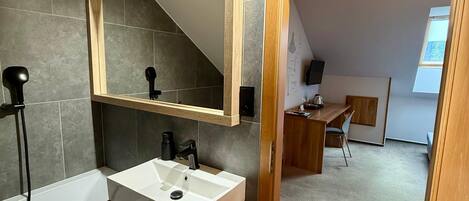 A modern bathroom with a bathtub, a sink, and a large mirror.