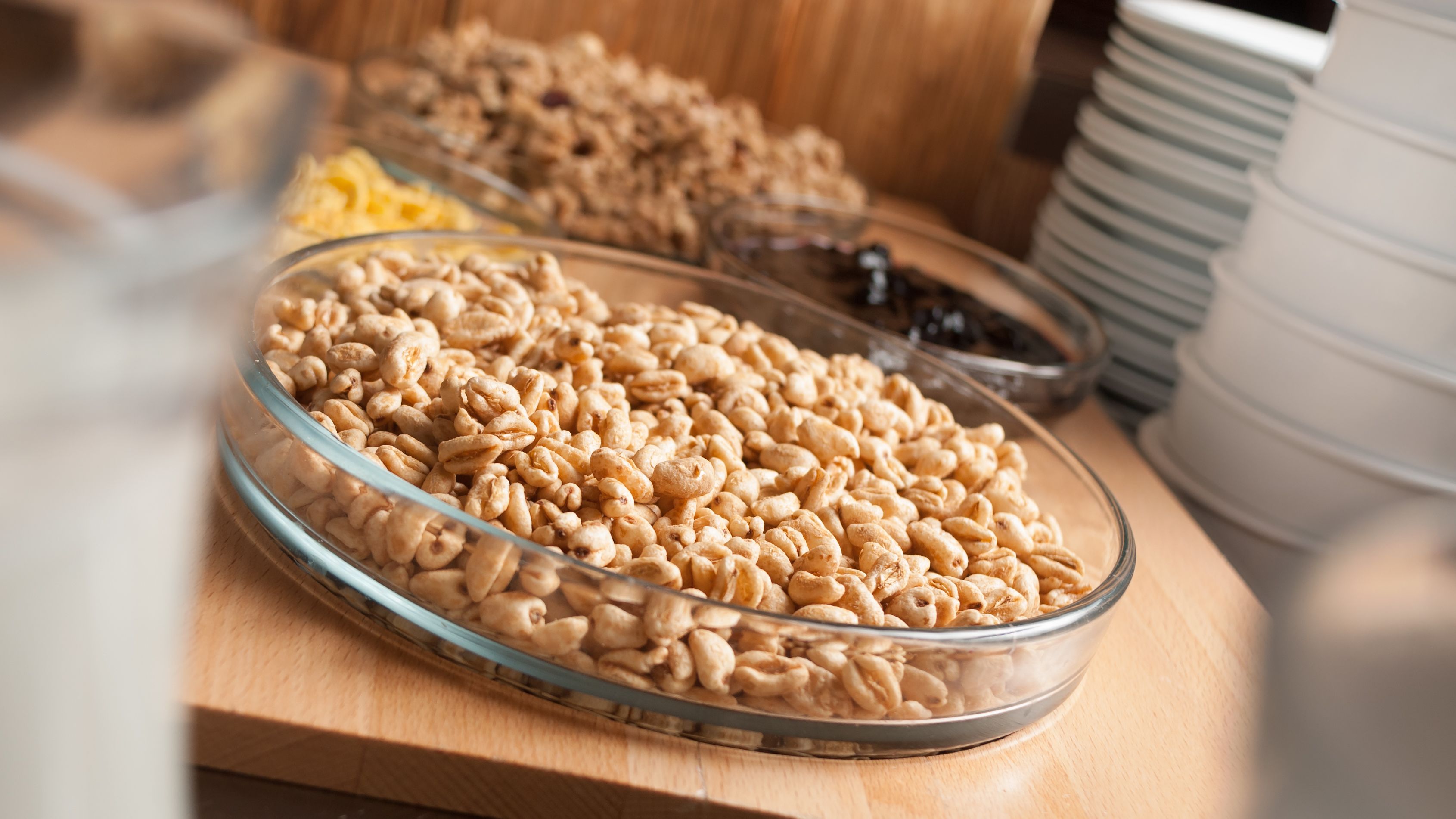 A glass bowl filled with cereal on a wooden surface.