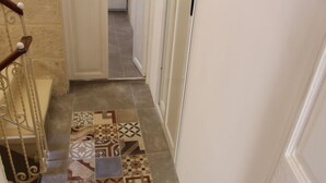 A hallway with patterned tiles and a metal railing. - VBL Hostel – Adults only (Valletta)