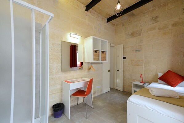 A bedroom with a bed, a desk, and a chair. - VBL Hostel – Adults only (Valletta)