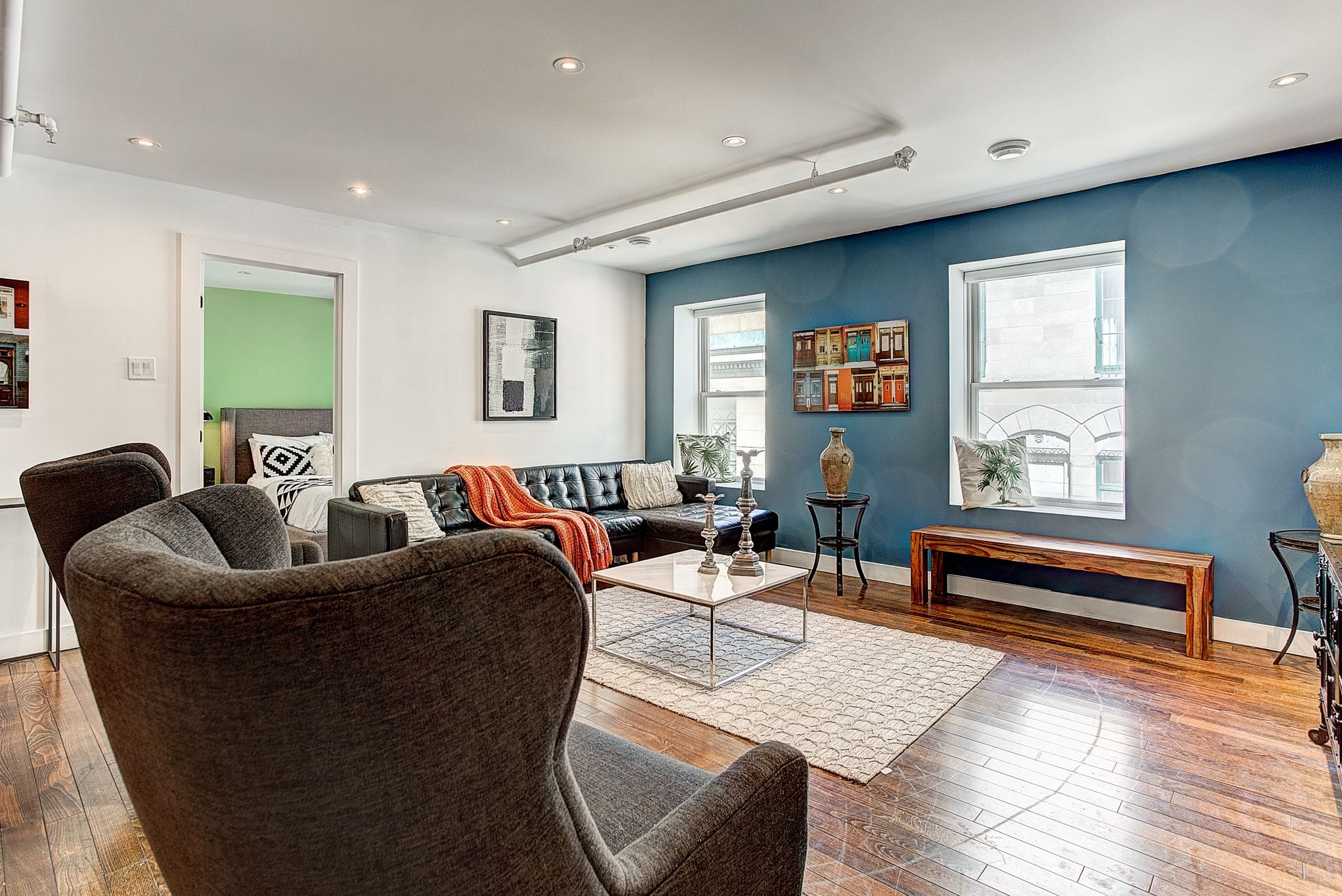 A modern living room with a sectional sofa, a coffee table, and a bench.