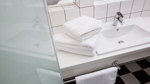 A bathroom with a white sink, a mirror, and a black and white checkered floor. - Landhaus Schulze Osthoff (Warendorf)