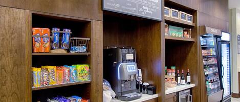 Ein Café mit einer Kaffeemaschine, Snacks auf Regalen und einer Kühlvitrine.