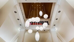A hotel interior with a modern chandelier and a visible 'Hilton' sign. - Hilton Garden Inn Salina (Salina)