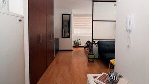 A modern office space with wooden flooring, a desk with a telephone, and a black office chair. - Studio Chapinero 216 (Bogotá)
