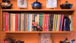 A bookshelf with various books and decorative items. - Apartment Chapinero 404 (Bogotá)