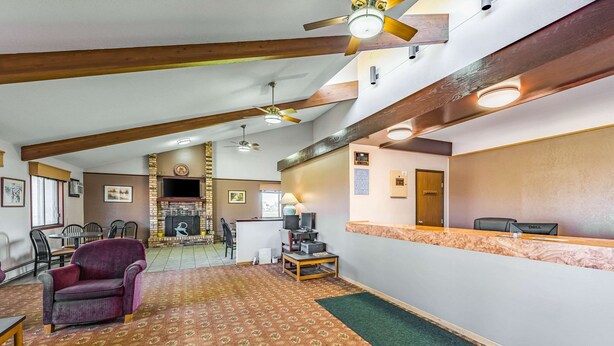 A spacious lobby with a reception desk, seating area, and a fireplace. - Rodeway Inn Saint Joseph (St. Joseph)