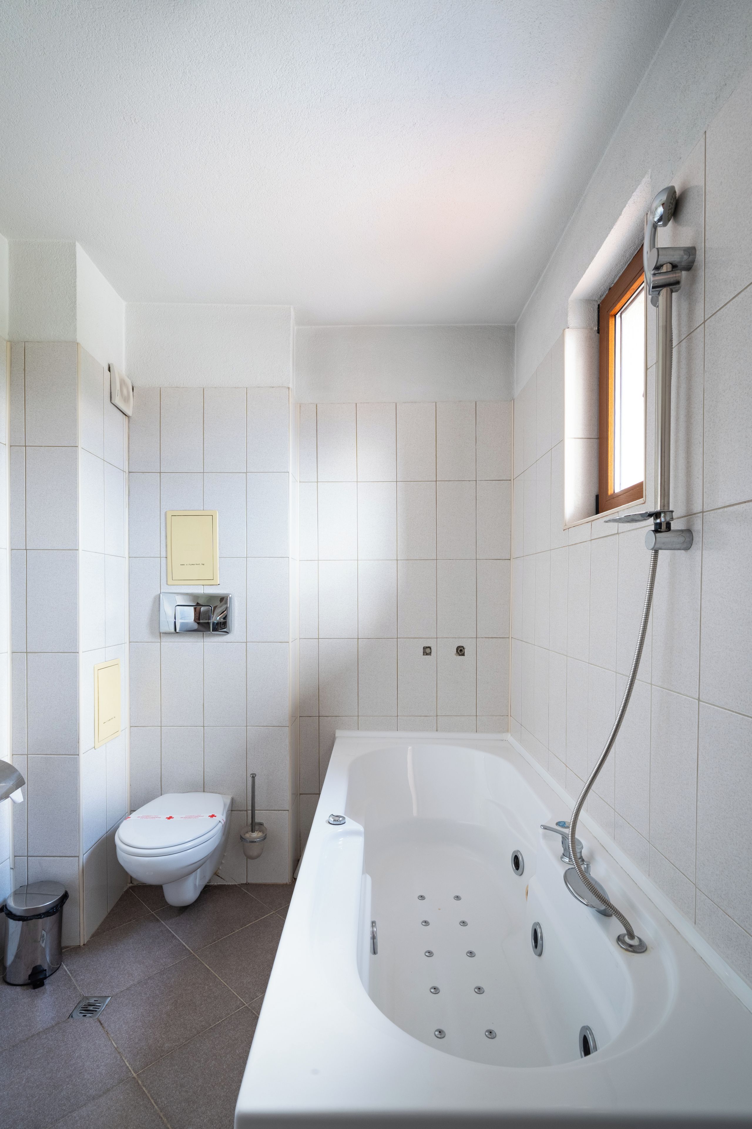 Ein modernes Badezimmer mit einer Badewanne, Toilette und einem Händetrockner.