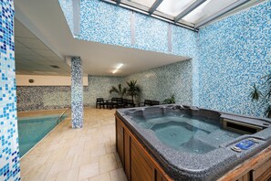 A hot tub in a room with tiled walls and a pool. - Kap House Hotel (Bansko)