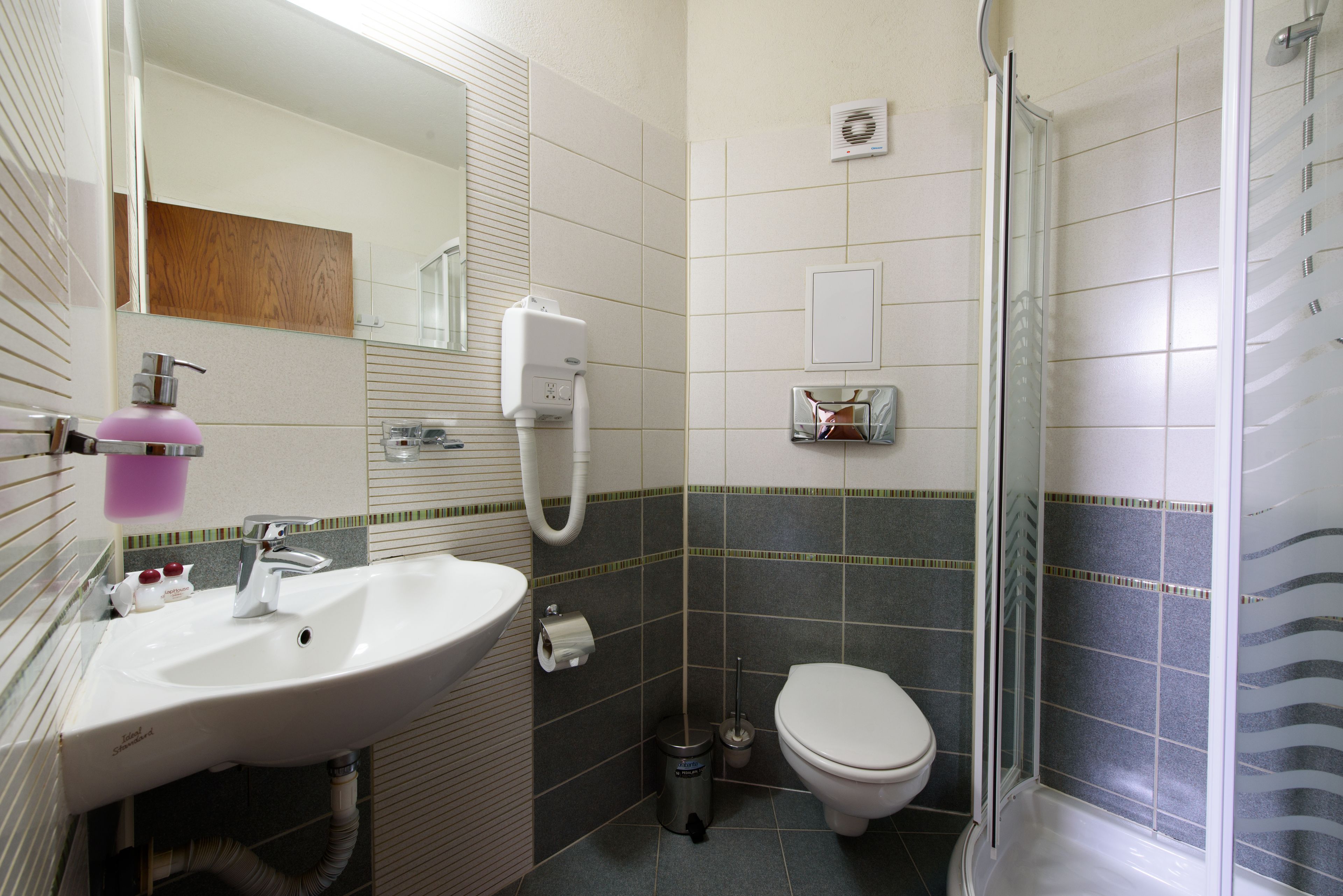 A bathroom with a sink, toilet, and shower.