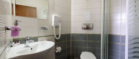 A bathroom with a sink, toilet, and shower.