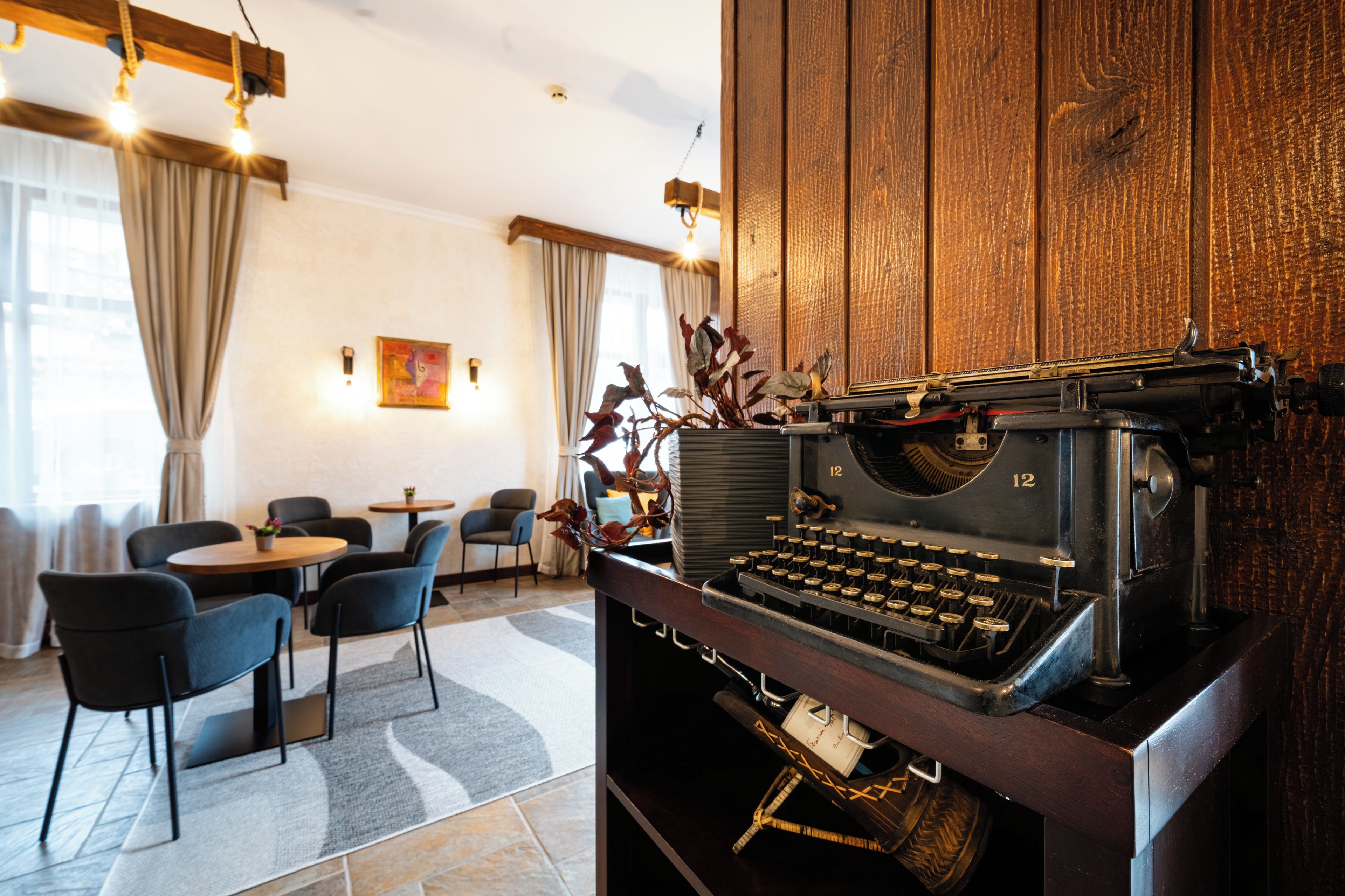 Una habitación con una máquina de escribir antigua, muebles modernos y una pared de acento de madera.
