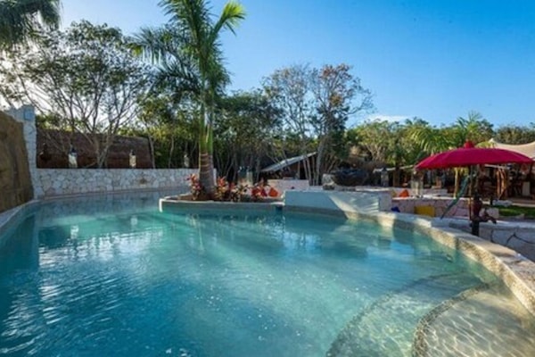 Una piscina al aire libre, sillones reclinables de piscina