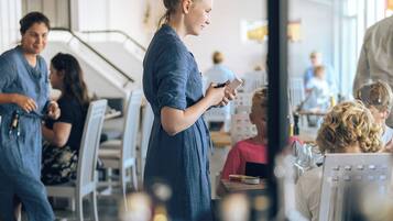 Un restaurant au décor moderne, avec des murs blancs et différents types de sièges, notamment des tables et des chaises.