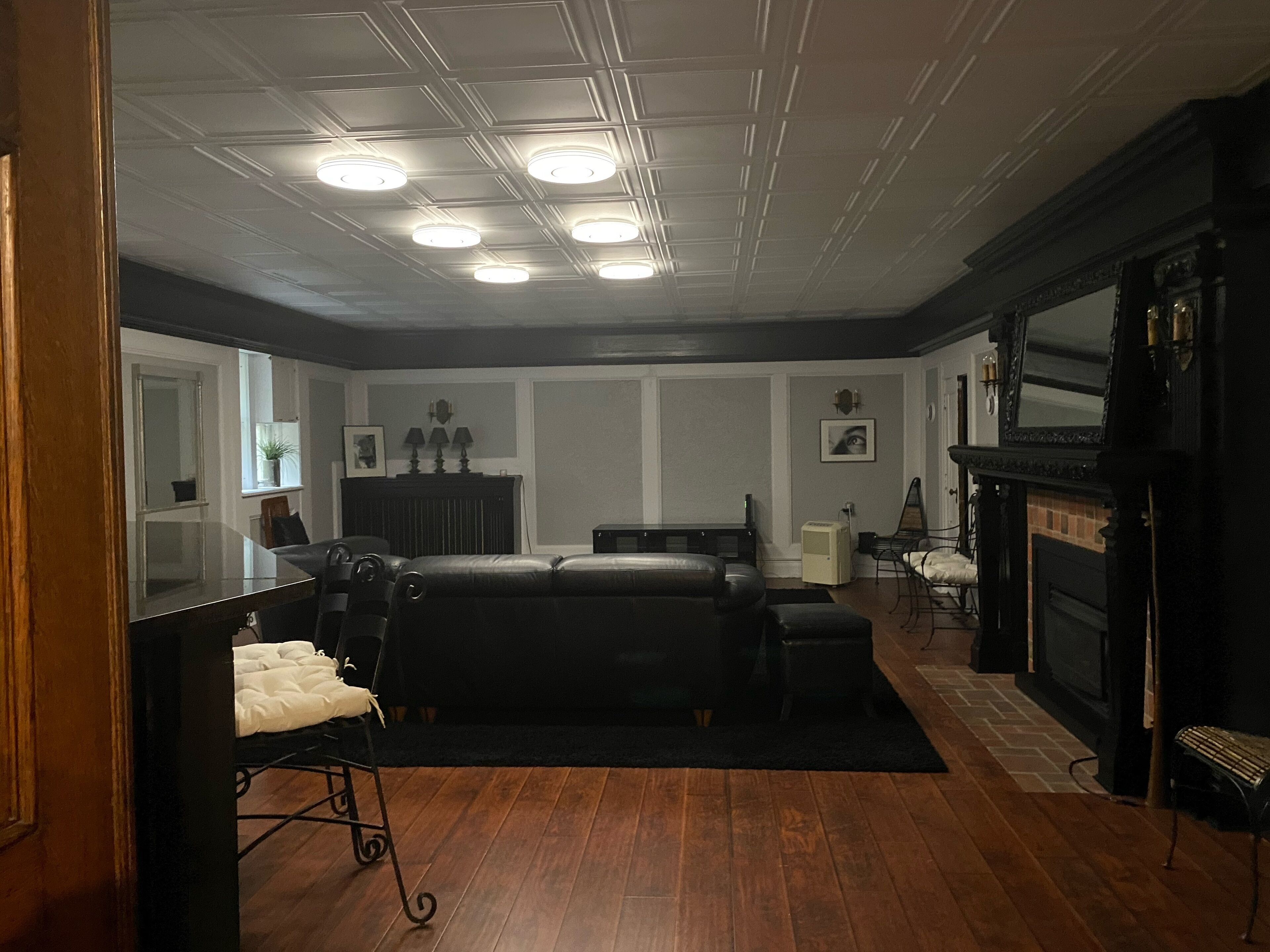 A room with a bed, a desk, a fireplace, and a mirror.