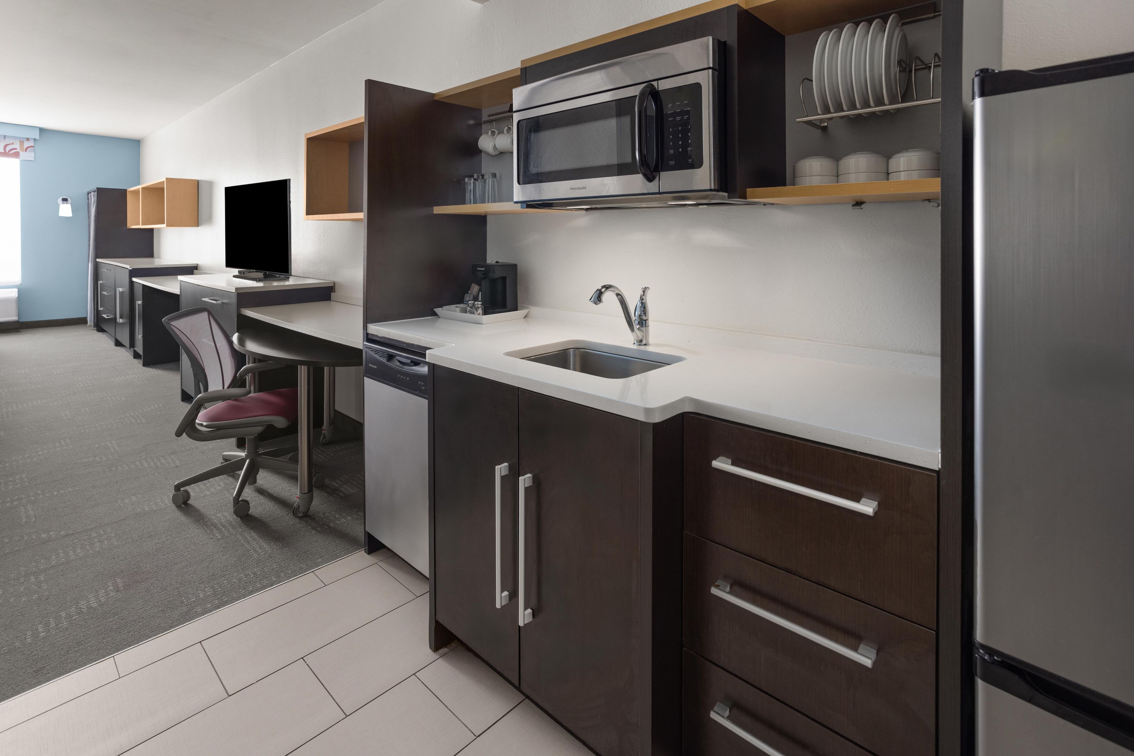 A modern kitchen with a stainless steel refrigerator, a microwave, and a coffee maker.
