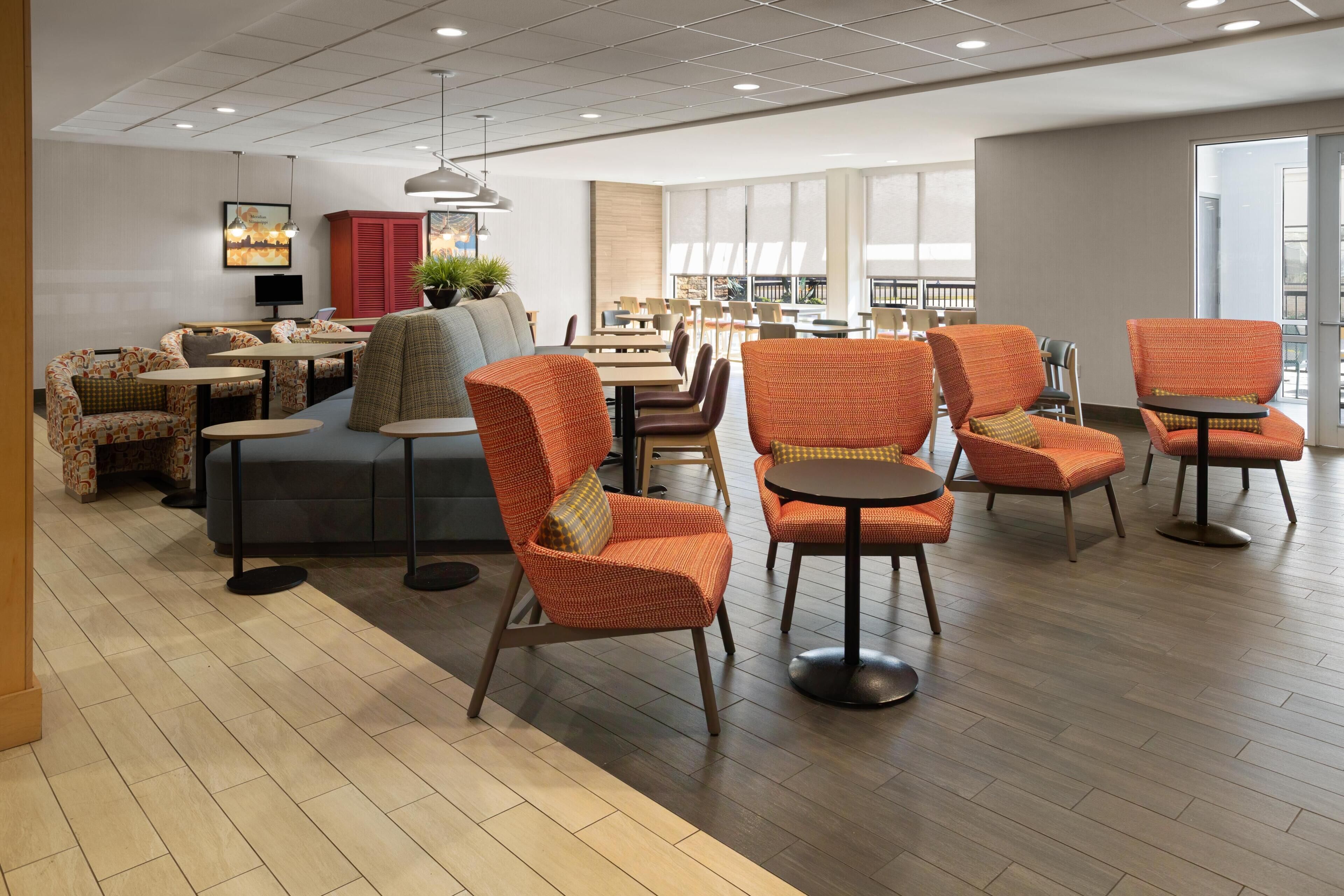 A spacious indoor area with multiple seating options including sofas, chairs, and tables.