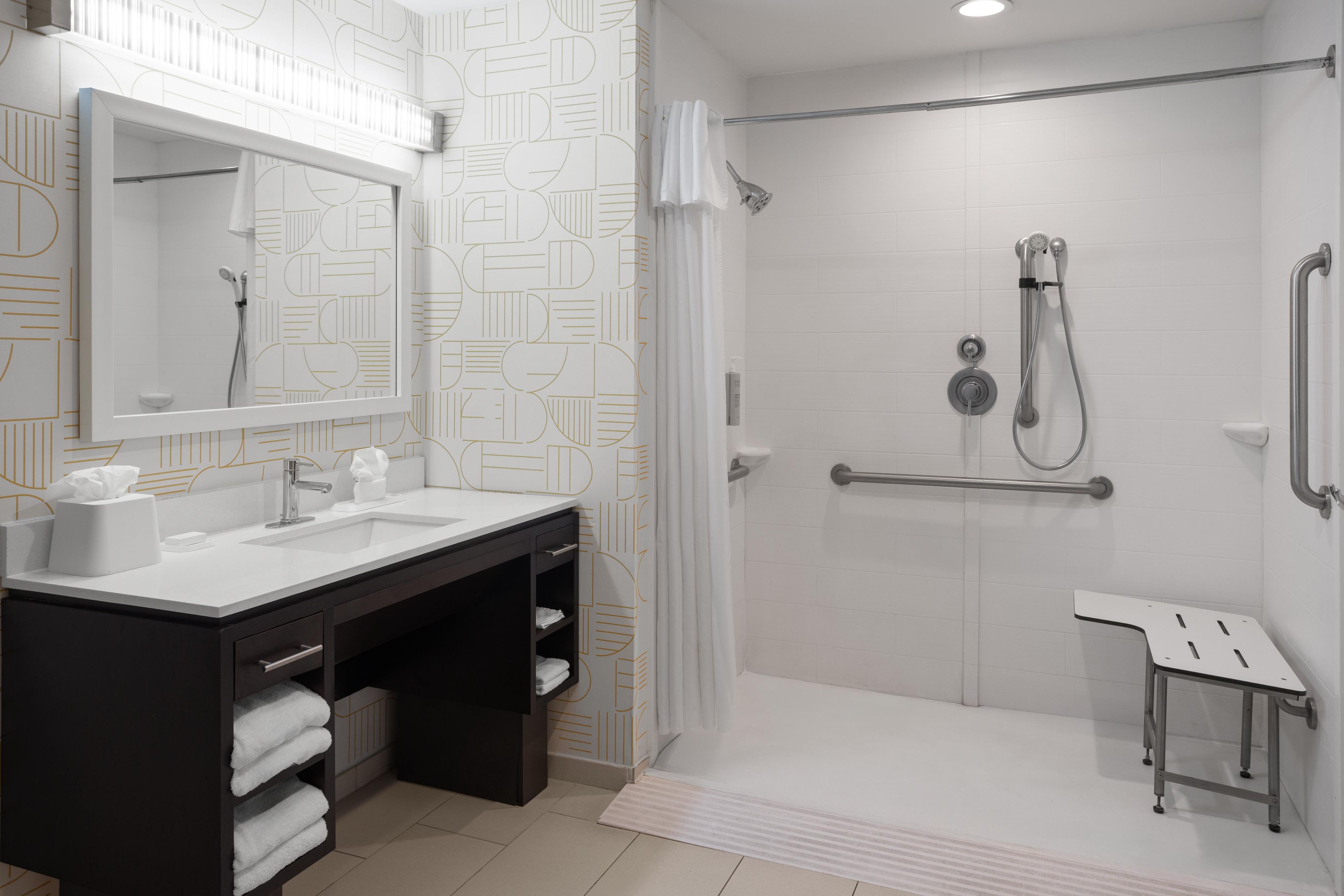 A modern bathroom with a shower, a sink, and a vanity.