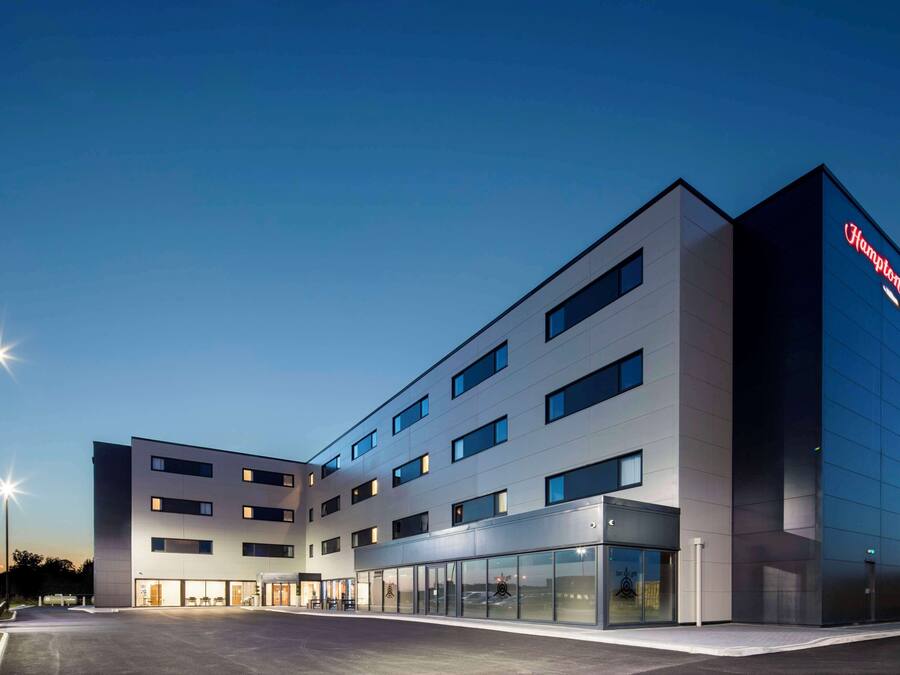Een modern hotel met een platte gevel, grote ramen en een opvallend merkbord.