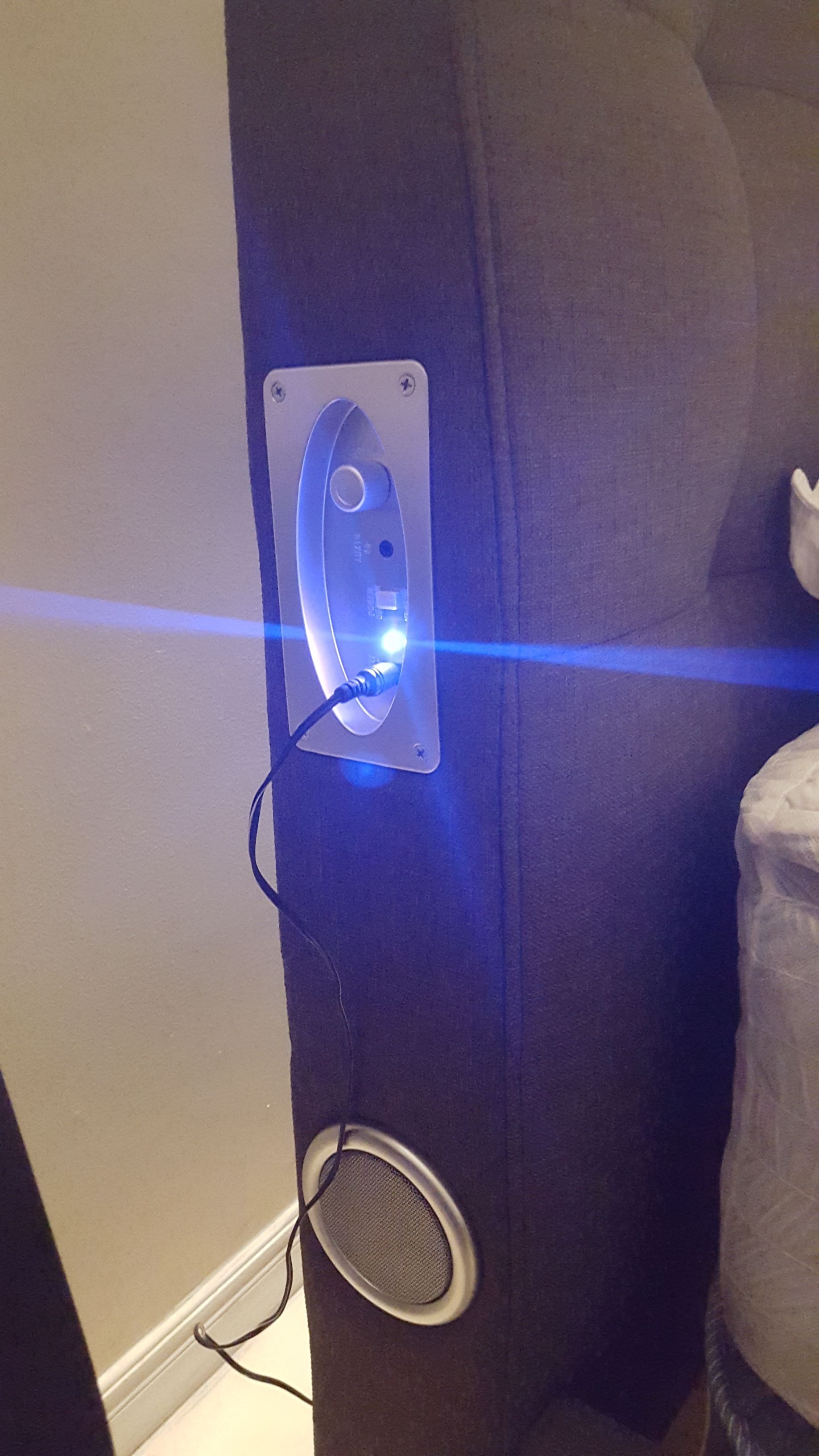 A wall-mounted device with a cable connected to it, possibly a security or intercom system.
