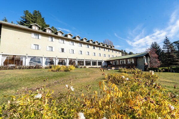 Un hotel de varios pisos con techo plano, ventanas amplias y una zona exterior cubierta.