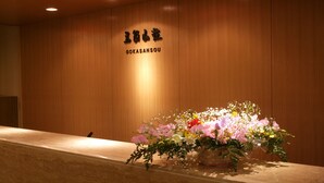 A reception desk with a wooden wall and a sign above it. - Gokasanso (Nanto)