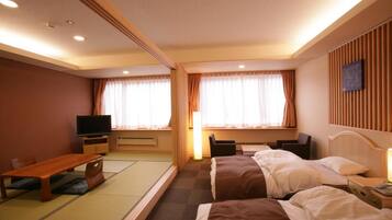 A hotel room with two beds, a desk, a television, and a futon.