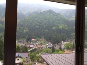 A view of a residential area with houses and a forested hill in the background. - Gokasanso (Nanto)