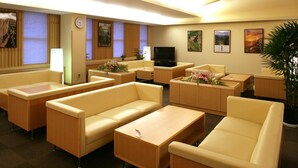 A hotel lobby with sofas, a TV, and artwork on the walls. - Gokasanso (Nanto)