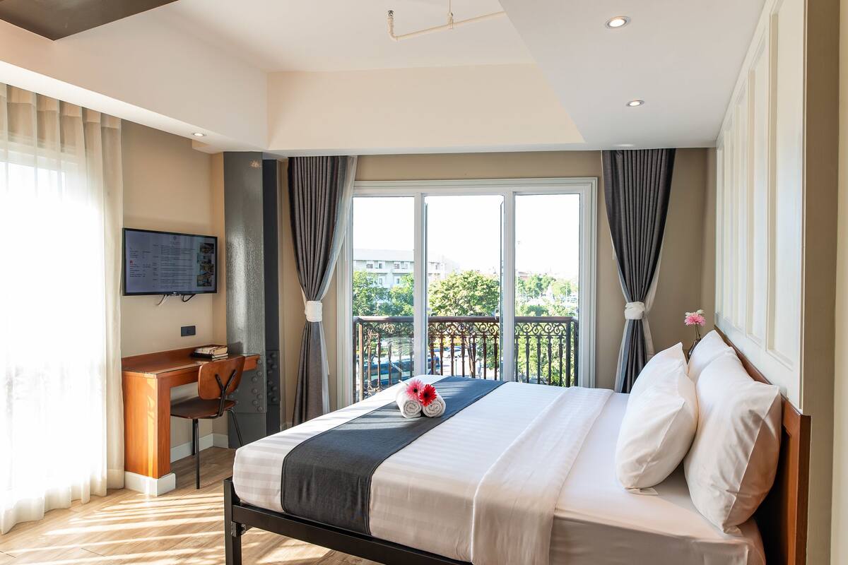 Une chambre d’hôtel avec un lit, un bureau et une télévision.