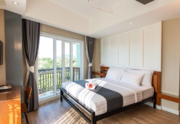 A hotel room with a bed, a desk, a chair, and a balcony with a view. - Dang Derm in The Park Khaosan (Bangkok)