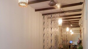 Un salon chaleureux, doté de meubles en osier, d’un plancher en bois et de panneaux d écoratifs.